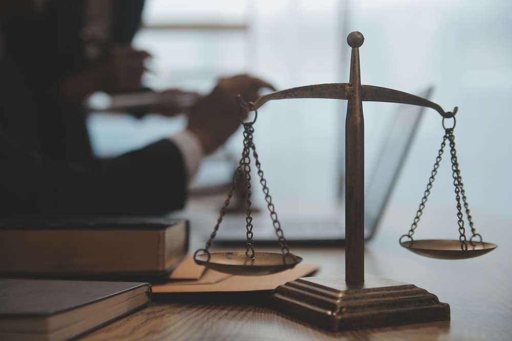 Judge's gavel with lawyers meeting at law firm — symbolizing legal services and justice.
