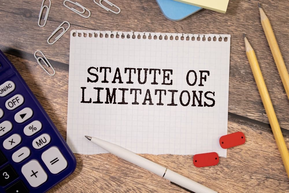 Law and justice concept: A notebook labeled 'Statute of Limitations' rests against the backdrop of the South African flag.