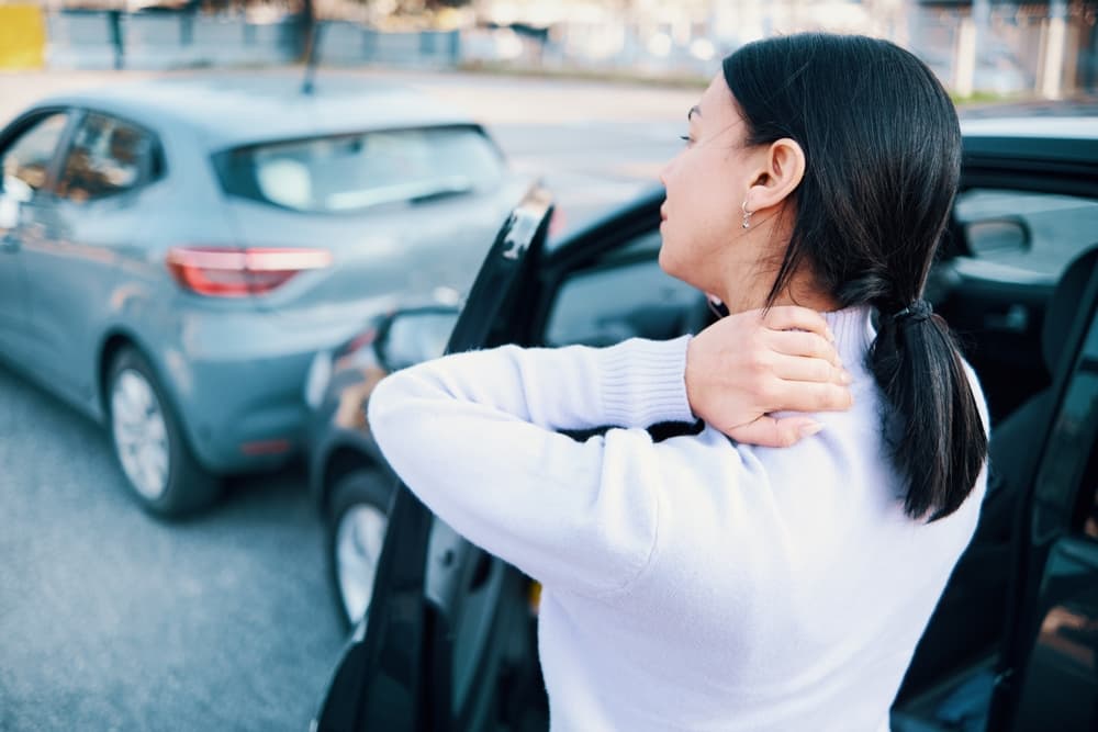 Woman suffering neck pain after car accident pile-up
