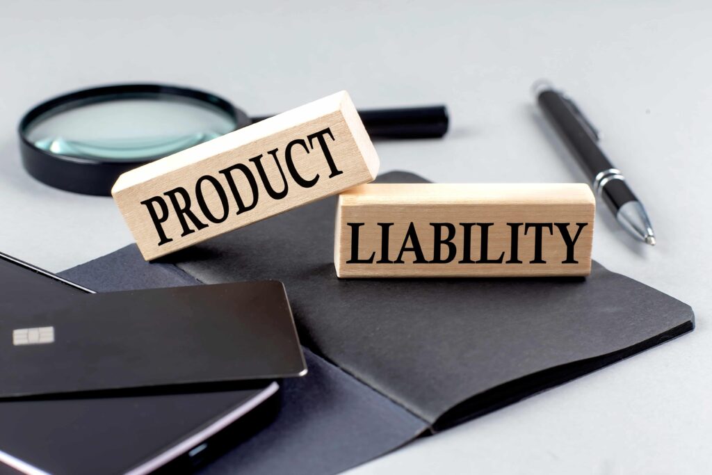 Product liability concept with wooden blocks, magnifying glass, and pen on desk Product liability concept with wooden blocks, magnifying glass, and pen on desk